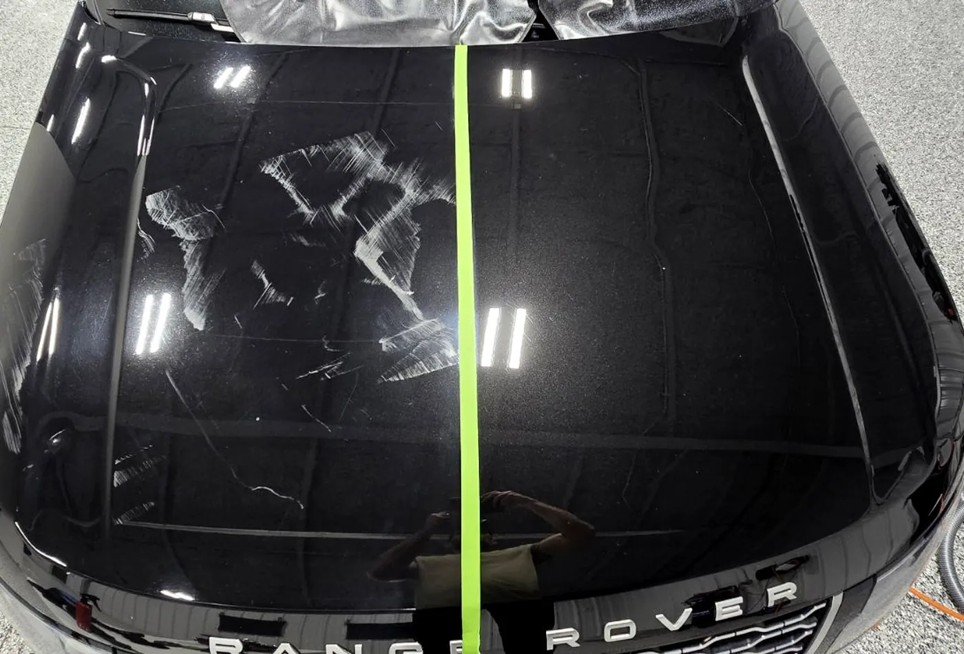 A Range Rover hood taped down the middle, corrected on one side only