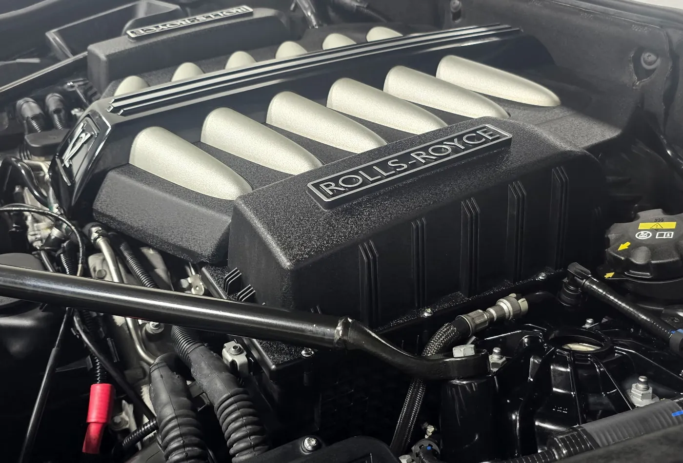 A detailed Rolls-Royce engine bay with the hood raised