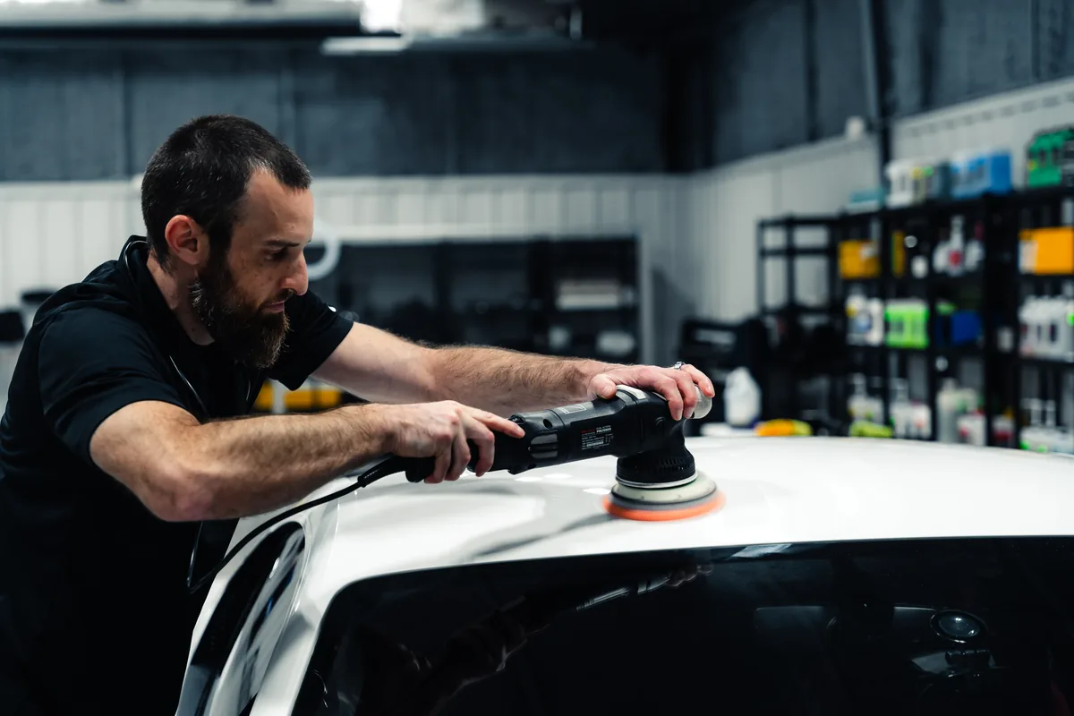 A Detail Geex technician machine polishing the roof of a white Audi R8
