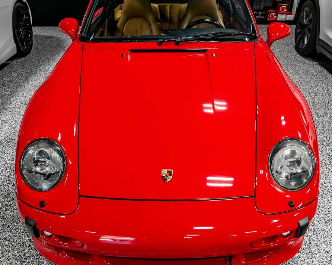 The front of a red Porsche 911 inside the studio