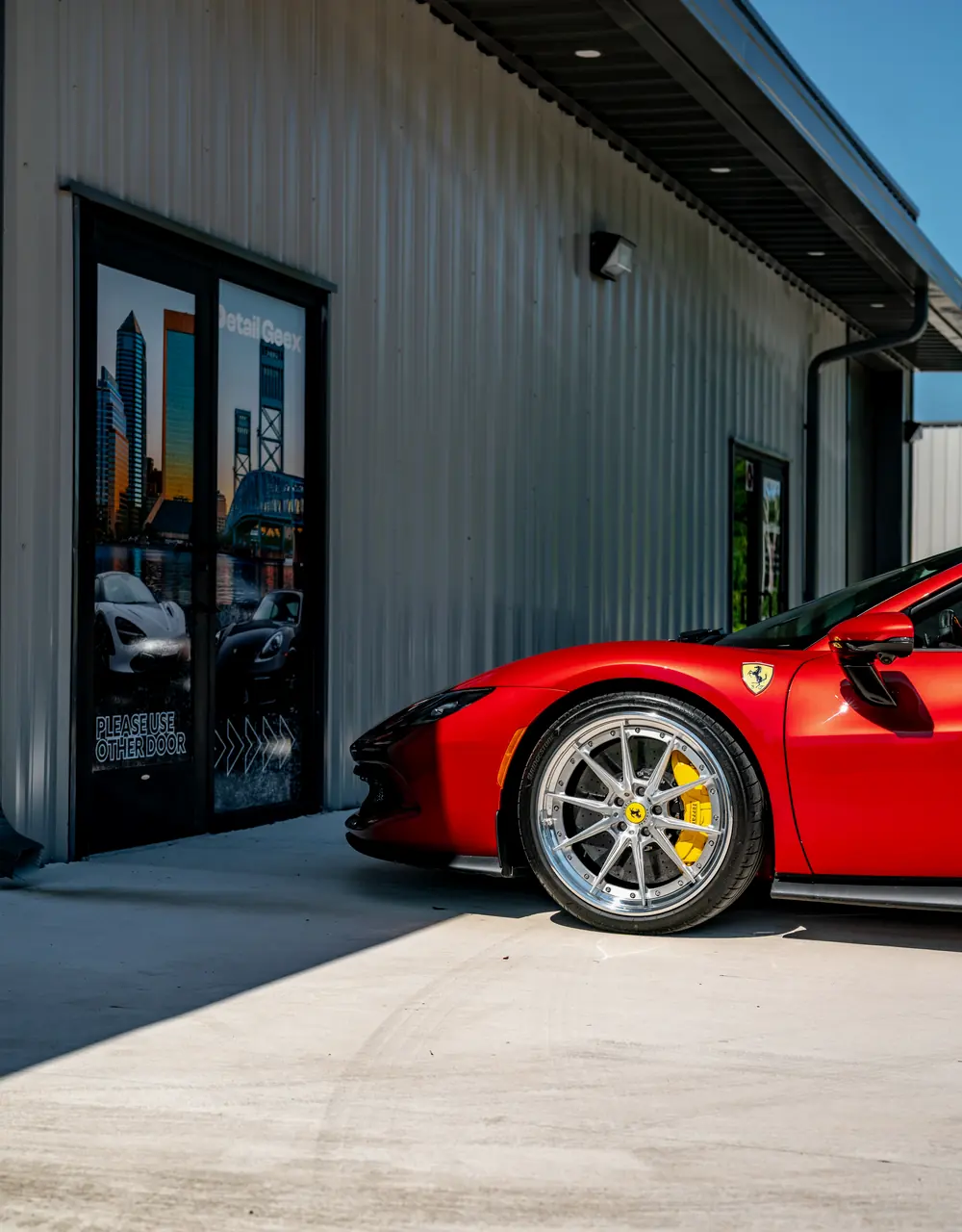 A red Ferrari outside the Detail Geex entrance