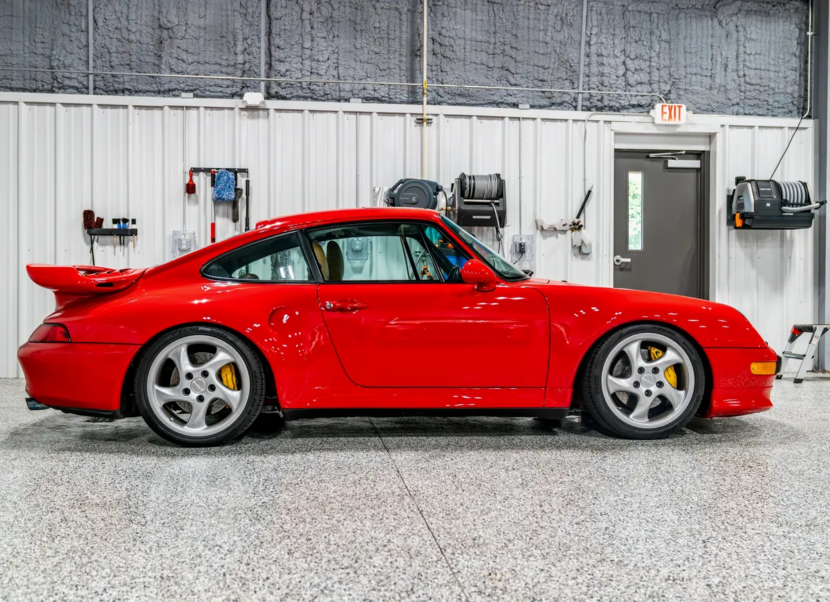 A red Porsche 911 in profile inside the bay