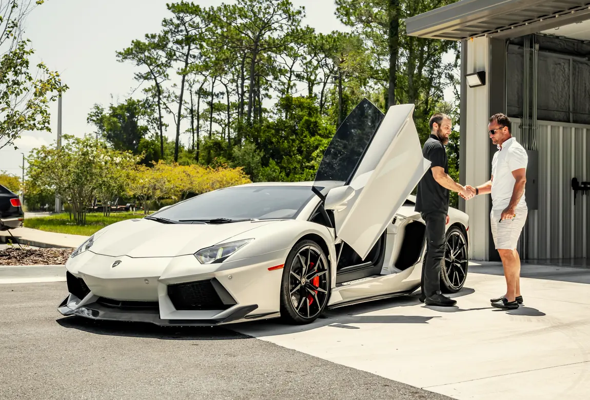 A white Lamborghini outside the studio with its owners