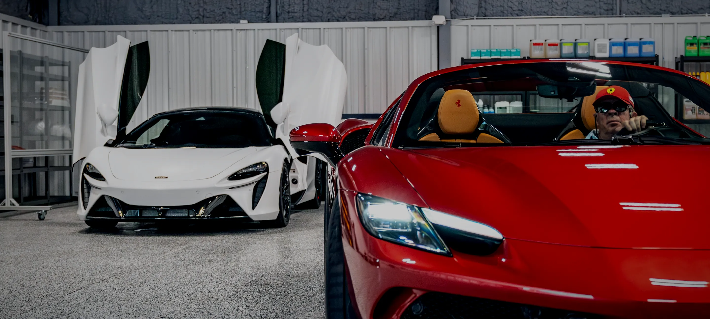 A white McLaren and a red Ferrari together inside the Detail Geex bay