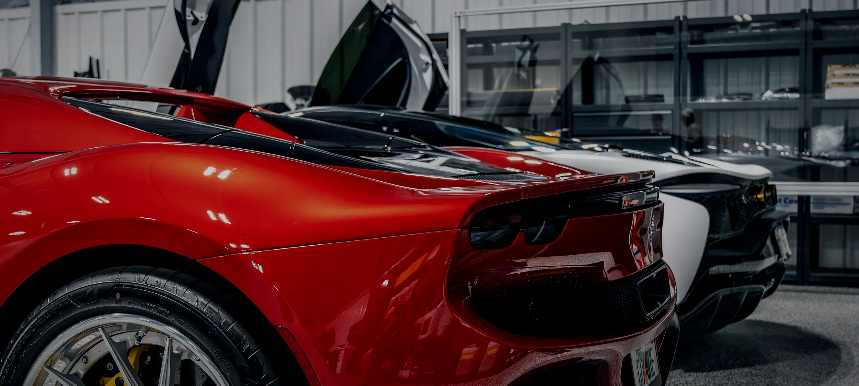 A red Ferrari and a McLaren inside the climate-controlled Detail Geex bay