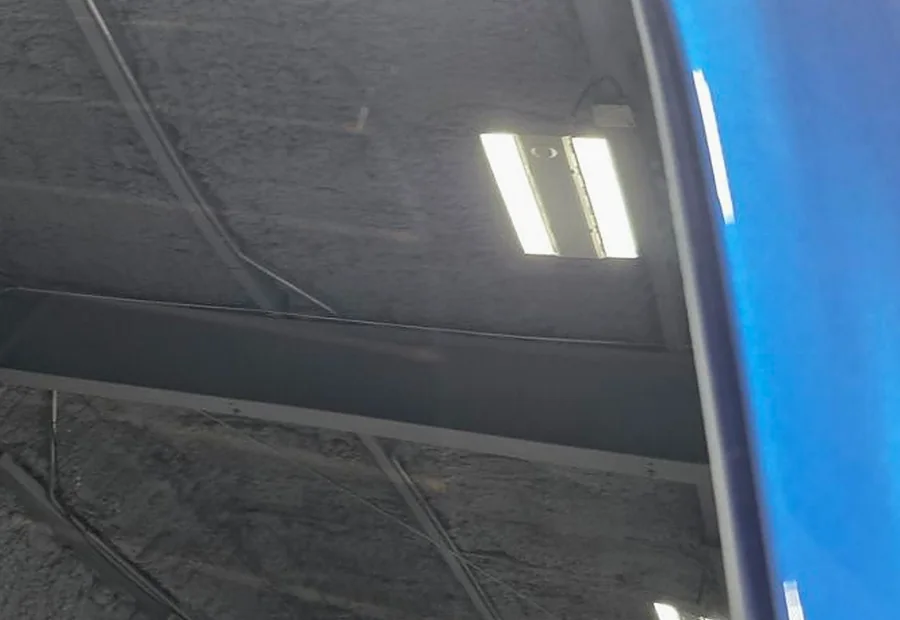 Restored rear quarter glass reflecting the studio ceiling cleanly